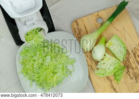 Сabbage In A Vegetable Cutter On Kitchen Table. Chopped Cabbage Is Falling Into A Bowl. Homemade Hea