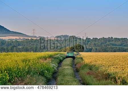 Green-blue Car Parked Offroad In Scenic Nature With View Of A Mountain And Forest. Natural Reservati