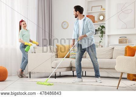 Spring Cleaning. Couple Tidying Up Living Room Together