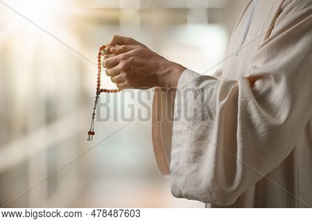 Muslim Man With Misbaha Praying On Blurred Background, Closeup