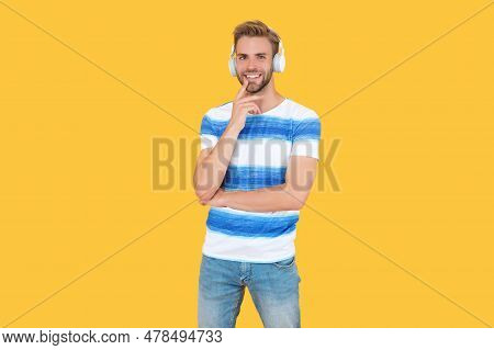 Cheerful Estudy Man Uses Headphones Isolated On Yellow Background. Young Estudy Man Attends An Onlin