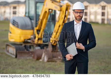 Construction Business Owner. Man In Suit And Hardhat Halmet At Building Construction Site. Civil Eng