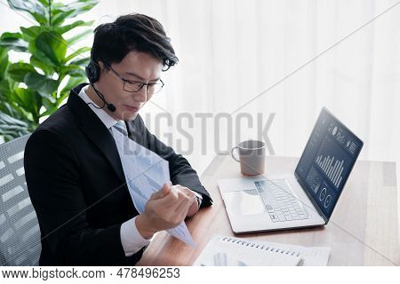 Confident Asian Telesales Businessman Work In Modern Office Wearing Headphone, Presenting Bi Dashboa