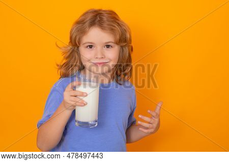 Cute Little Child With Glass Of Milk On Studio Color Background. Kid With Milk Moustache. Fun Portra
