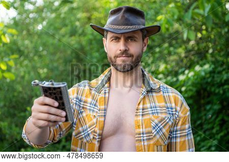 Man Offer Bourbon Hipflask Wear Checkered Shirt. Photo Of Cowboy Man With Bourbon Hipflask.