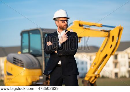 Construction Manager In Suit And Helmet At A Construction Site. Construction Manager Worker Or Super