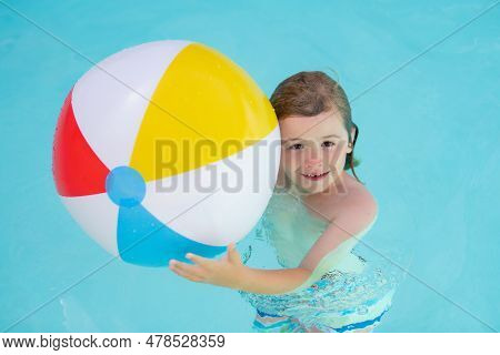 Kid Hold Rubber Air Ball In Pool. Happy Child Having Fun On Summer Vacation. Kid Playing With Ball I