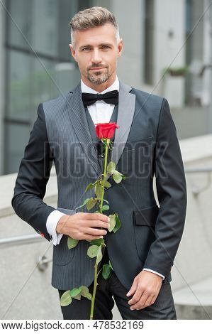 Elegant Man In Black Tux. Man Wearing Tux Bowtie Outdoor. Mature Tux Man With Red Rose