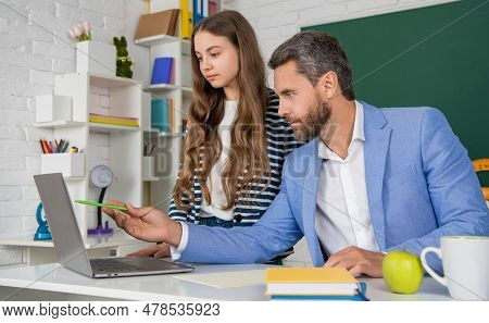 Kid With Tutor In Classroom Use Laptop