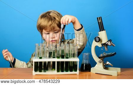 Smart Boy Working With Test Tubes And Microscope In School Classroom. Child Study Biology Chemistry.