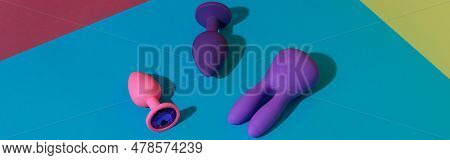Top View Of Buttplugs And Dildos Vibrator For Sex On Colored Background. Sex Shop Concept