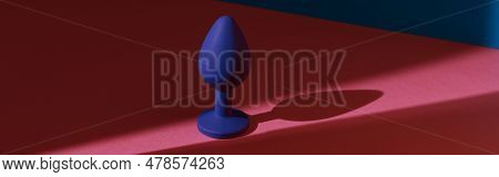 Blue Buttplug Sex Toy On A Colorful Background. Photo Of Anal Toy For Adult With Contrast Shadows