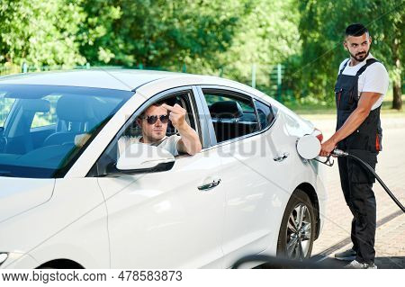 Rude Driver Showing Middle Finger To Other Car On Gas Station. Angry Man In Expensive Car Showing An