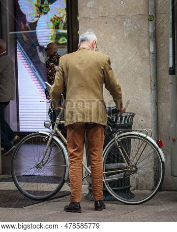 Well Dressed Man Parking A Bike In The Strett