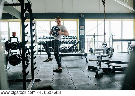 A Young Man Showcases His Strength And Dedication To Fitness Through A Weightlifting Workout In The 