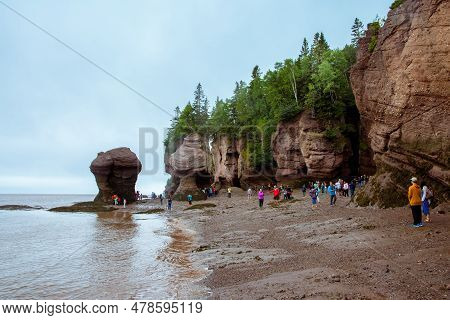 Bay Of Fundy, Canada - August 12, 2015:people Walk On The Bottom Of The Bay Of Fundy As The Tide Is 