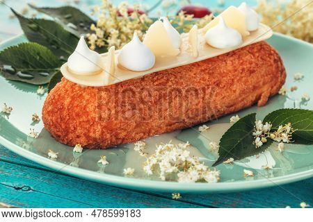 French Eclair Grazed With Chocolate Or Sweet Italian Profiteroles With Fresh Cold Dwarf-elder Juice,