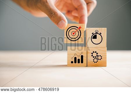 Wood Block Stacking Guided By A Hand, Illustrating The Concept Of Business Strategy And Action Plan.