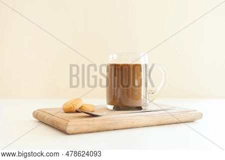 Hot Coffee Latte Or Cappuccino In Clear Coffee Glass On Beige Background With Roasted Beans And Spoo