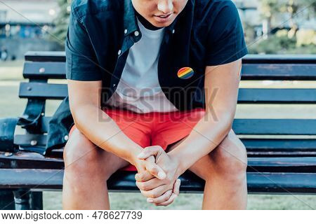 Cropped No Face Sad Frustrated Lgbtq Person With Rainbow Badge On T-shirt Sitting On Park Bench Alon