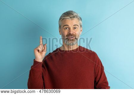 Excited Inspired Middle Aged Man Raising Finger Up On Blue