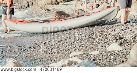 Happy Couple Kayaks In An Inflatable Kayak On The Sea At Sunset. Couple Kanoeing In The Sea Near The