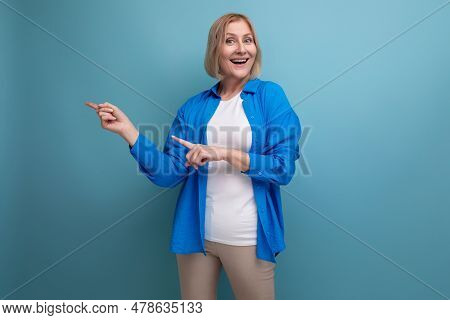 Pleasantly Surprised Mature Woman In Casual Shirt On Blue Background