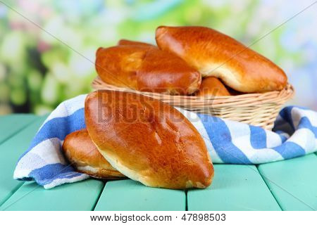 Empanadillas al horno frescos en cesta de mimbre, sobre fondo brillante