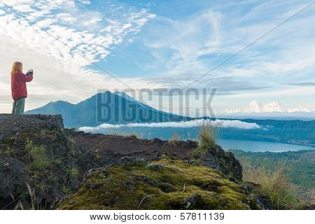 Young woman tourist photographing landscape