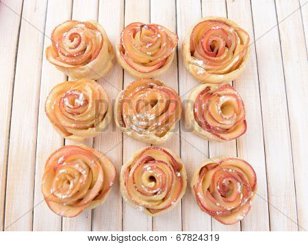 Tasty  puff pastry with apple shaped roses on plate on table close-up