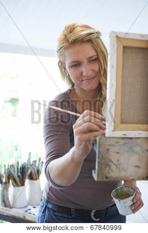 Female Artist Painting In Studio