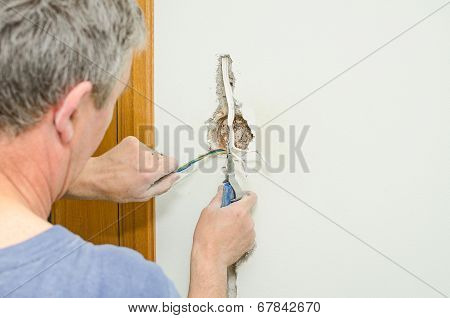 Certified Electrician Installing Socket For Light Switch.