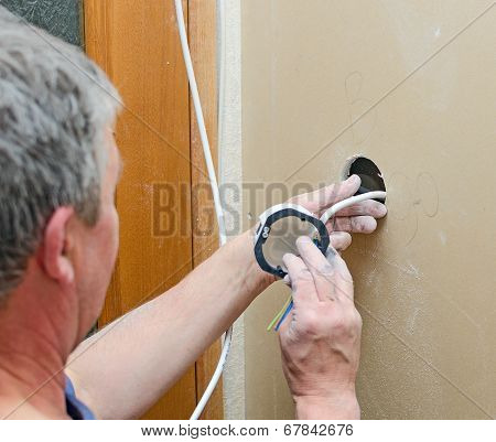 Certified Electrician Installing Socket For Light Switch.