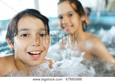 Happy little boys enjoying relaxing and splashing in water
