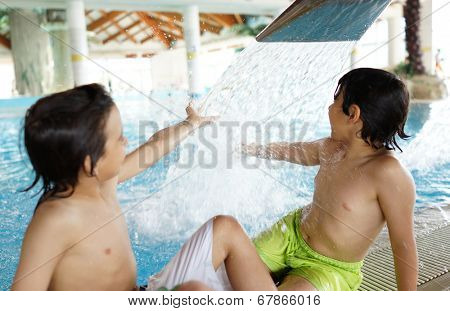 Happy little boys enjoying relaxing and splashing in water