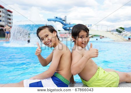 Happy little boys enjoying relaxing and splashing in water
