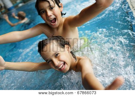 Happy little boys enjoying relaxing and splashing in water