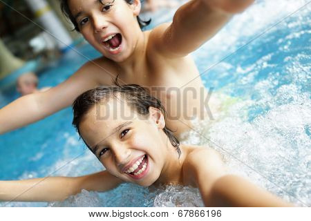 Happy little boys enjoying relaxing and splashing in water