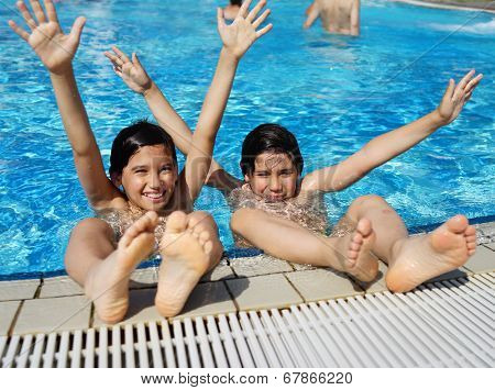 Happy little boys enjoying relaxing and splashing in water