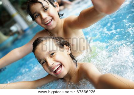Happy little boys enjoying relaxing and splashing in water
