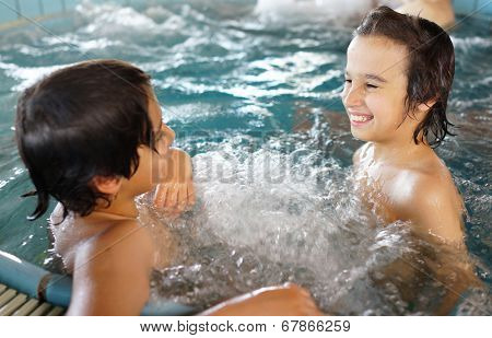 Happy little boys enjoying relaxing and splashing in water