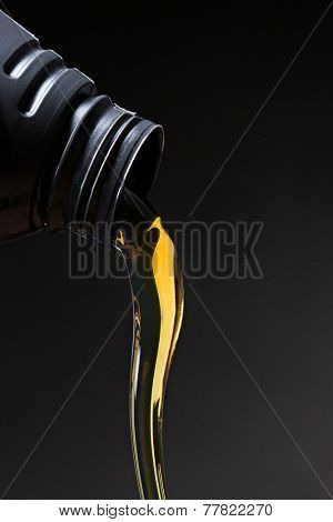 Motor oil pouring over black background