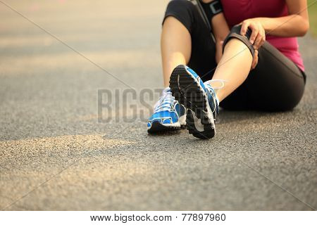 woman runner hold her sports injured knee outdoor