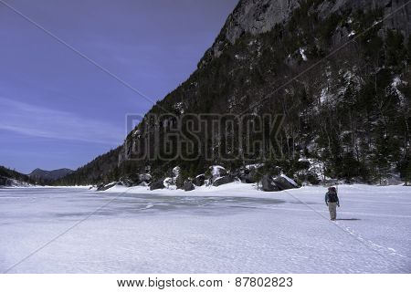 Man Trecking Across A Frozen Lake