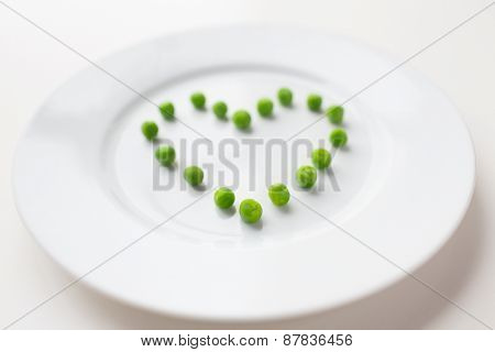 healthy eating, dieting, vegetarian food and cooking concept - close up of plate with peas in shape of heart