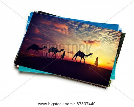 Holidays travel concept creative background - stack of vacation photos with camel caravan sunset image on top isolated on white background
