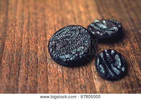black buttons on wooden background