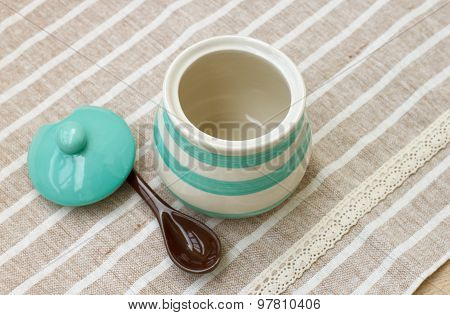 Green pastel porcelain jar and brown spoon with cute fabric.