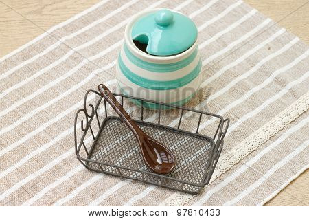 Green pastel porcelain jar and brown spoon with cute fabric.
