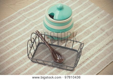 Green pastel porcelain jar and brown spoon in vintage style.